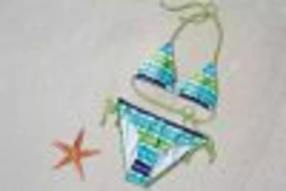 Estrella de mar en la arena junto a un bikini