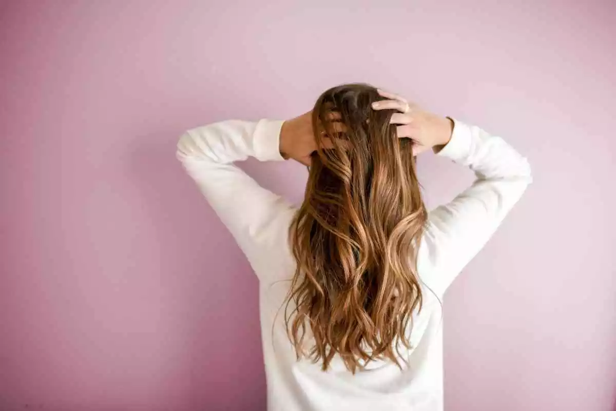 Fotografía trasera de una mujer tocándose el pelo