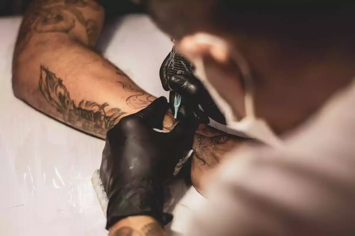 Tatuador haciendo un tatuaje