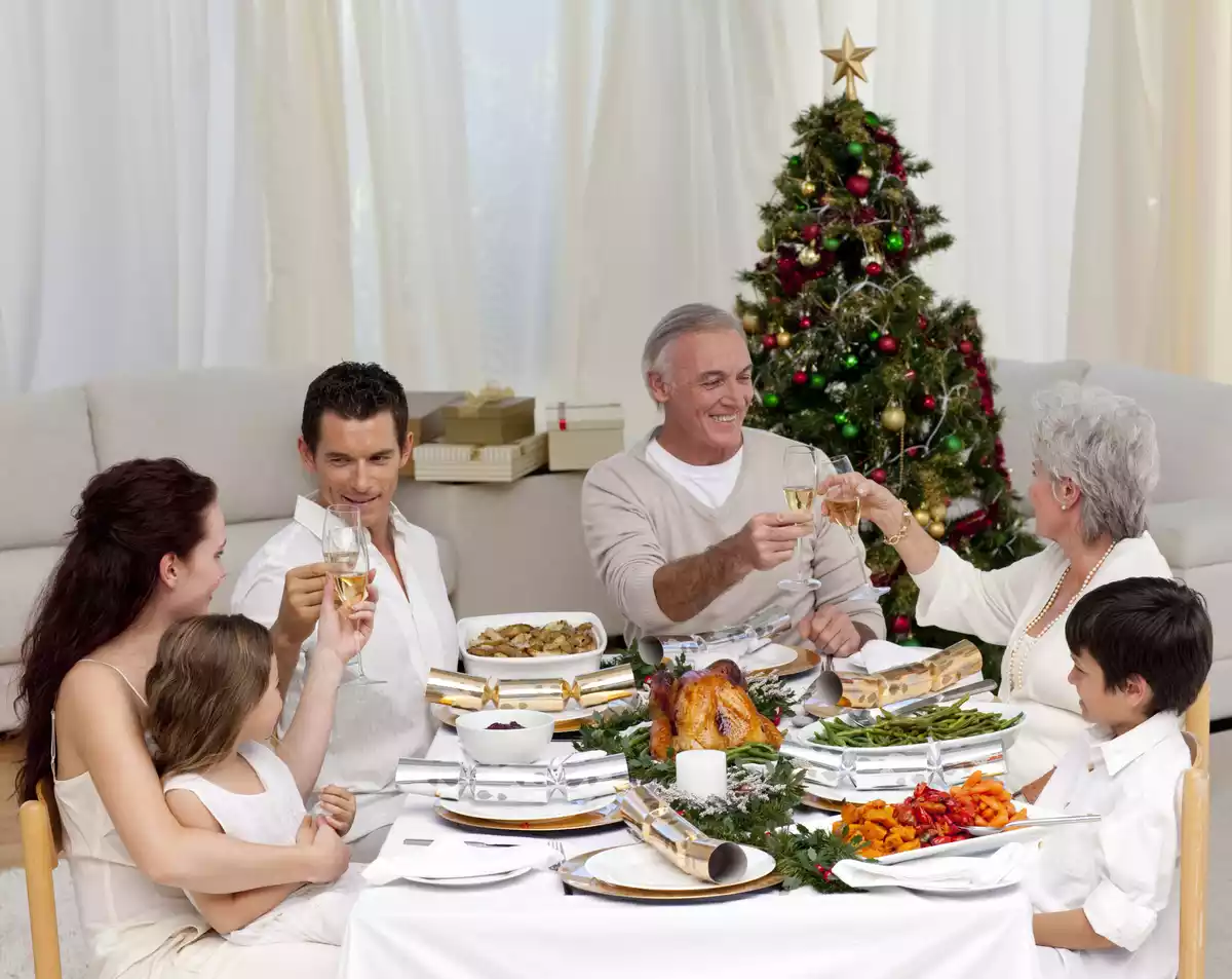 Cena familiar de navidad con el árbol de fondo