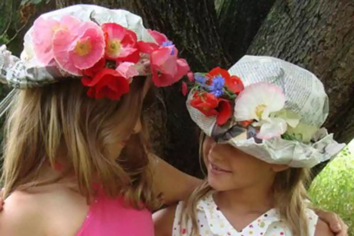 Dos niñas con sombrero de papel