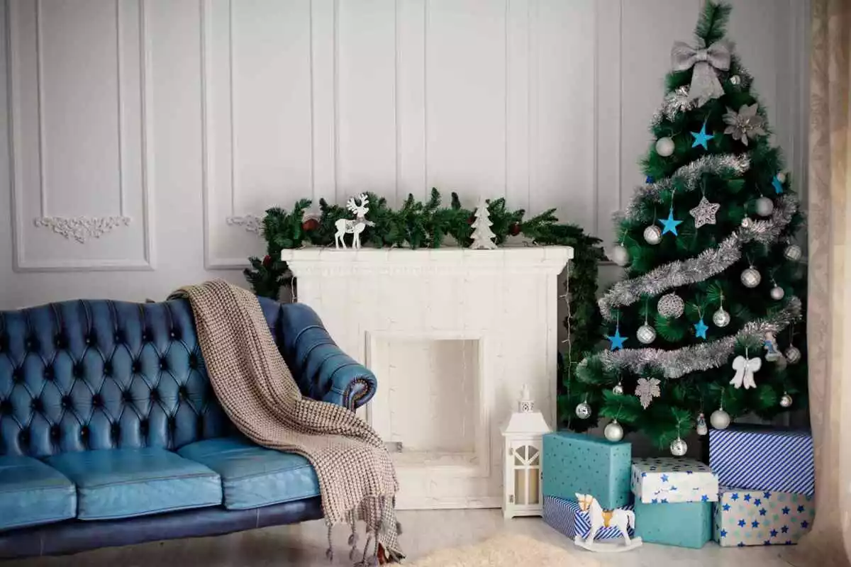 Con un árbol de Navidad y una chimenea blanca junto a la chimenea