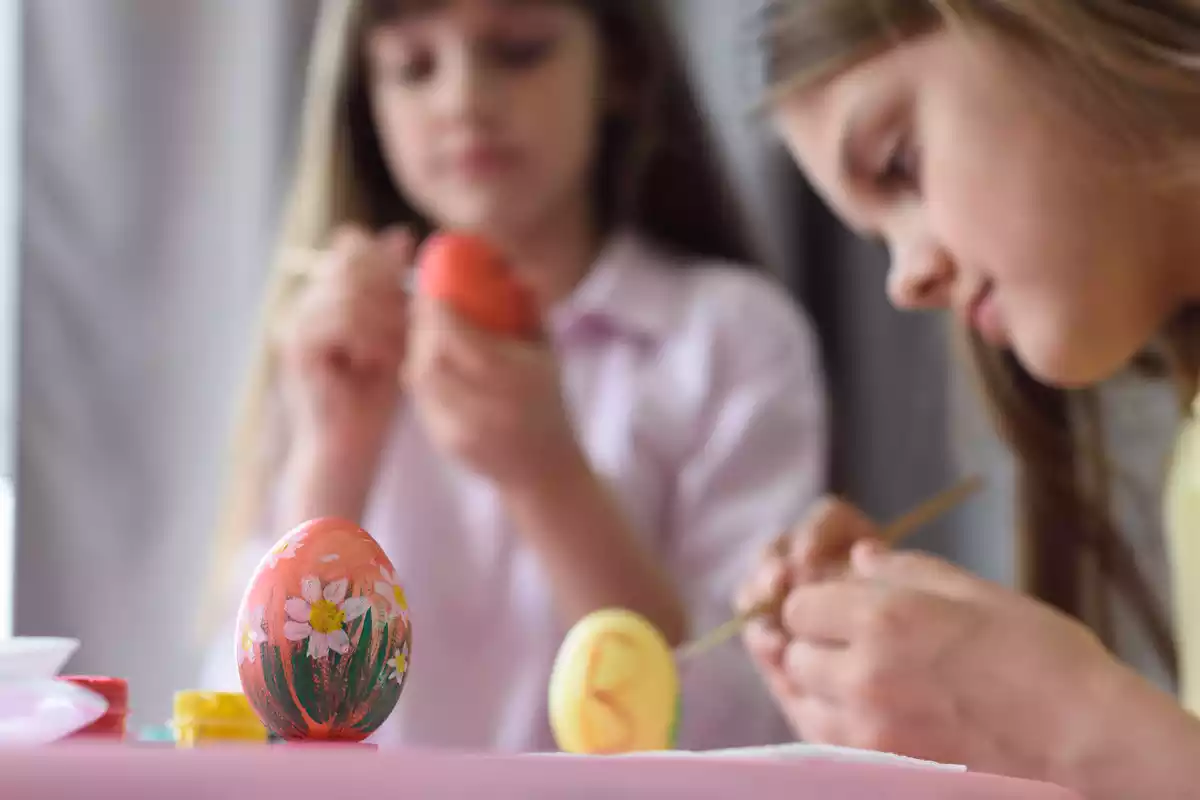 Dos niñas decorando huevos de pascua