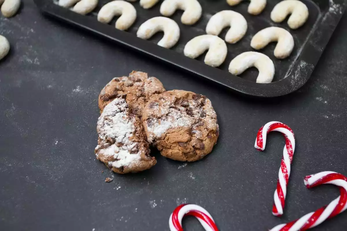 Foto con galletas y gominolas navideñas sobre fondo negro