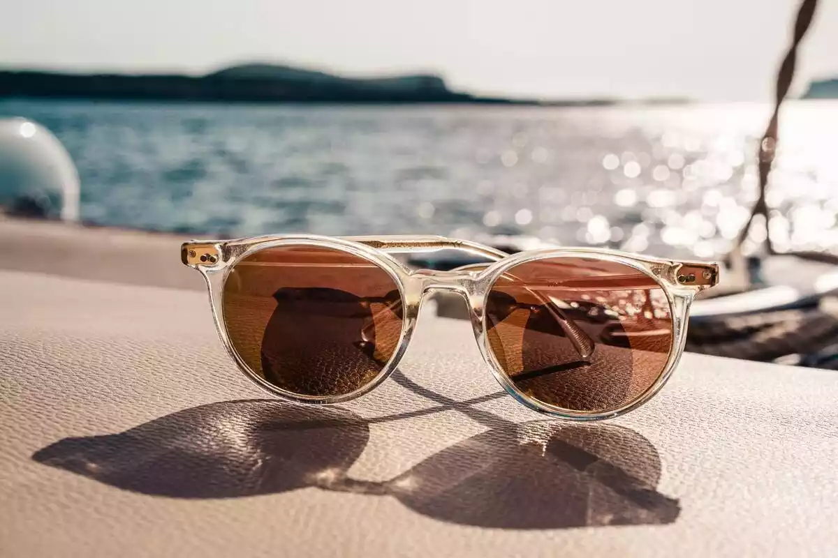 Gafas de Sol con cristales marrones y fondo de sol y mar