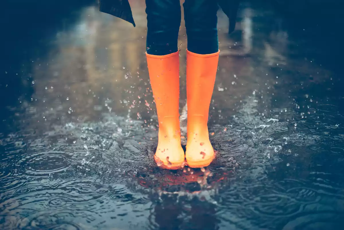 Imagen de alguien con unas botas de lluvia naranjas