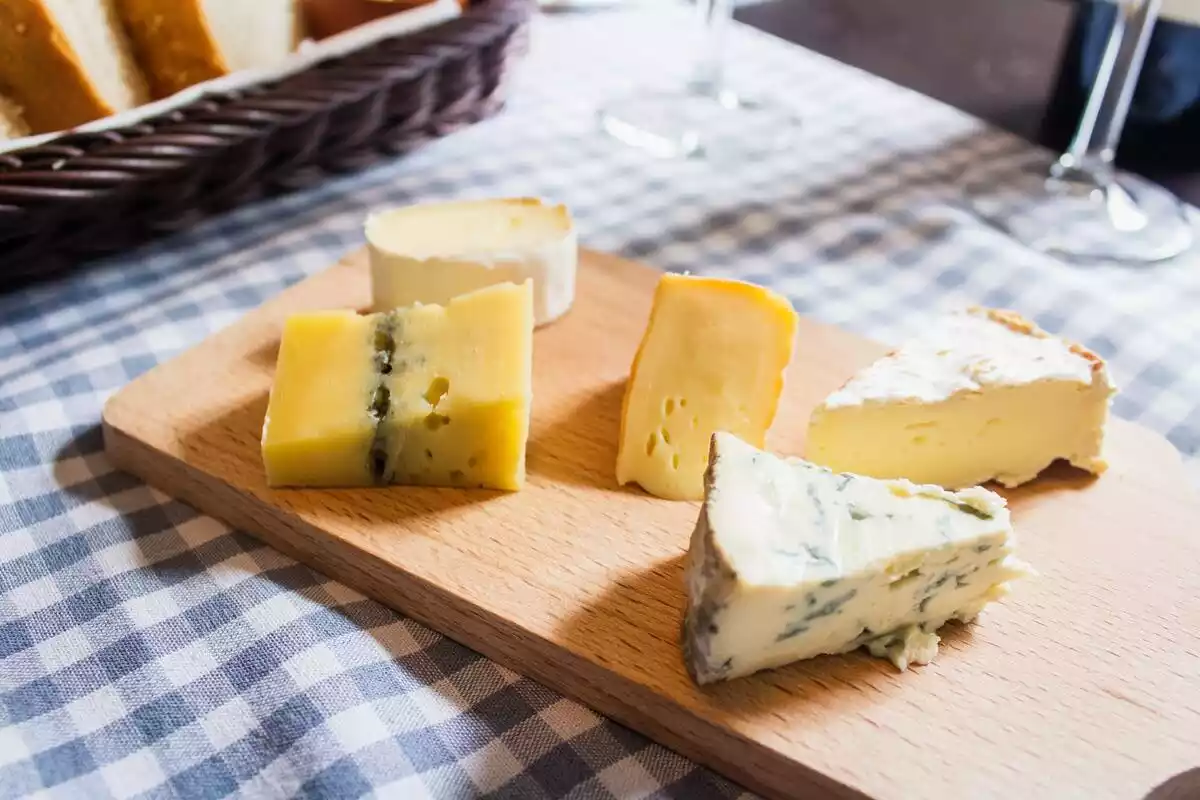 Varios tipos de queso encima de una tabla de madera